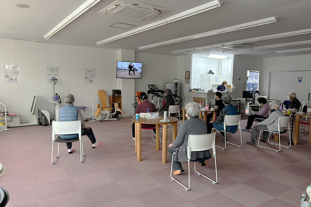 運動機能向上に特化した施設内部。理学療法に基づいたリハビリマシンのほか、有酸素運動用のトレッドミル、円卓を囲んでリラックスできる休憩スペースが整った開放的な空間。