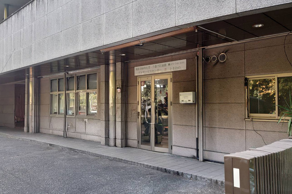 京都市右京区にある「デイサービスセンター 恵 ときわの」の入り口外観。重厚な石造りのビル1階に位置している